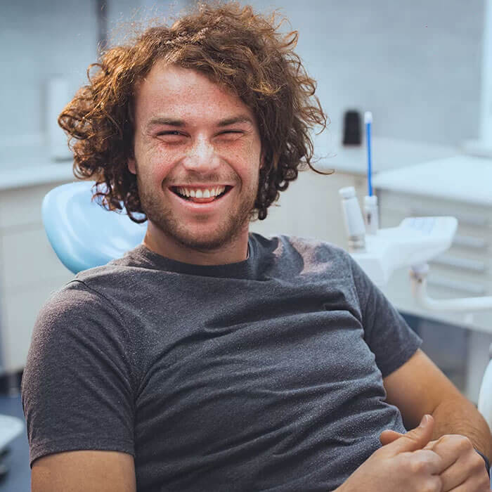 smiling young man in dentist chair