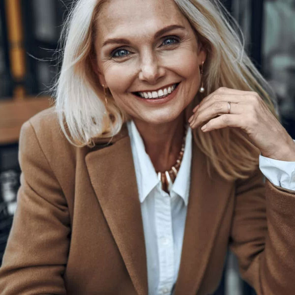 Mature woman in brown coat smiling