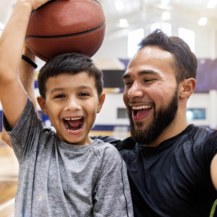 Father takes selfie while son holds a basketball on head