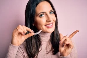 Women holding clear aligners